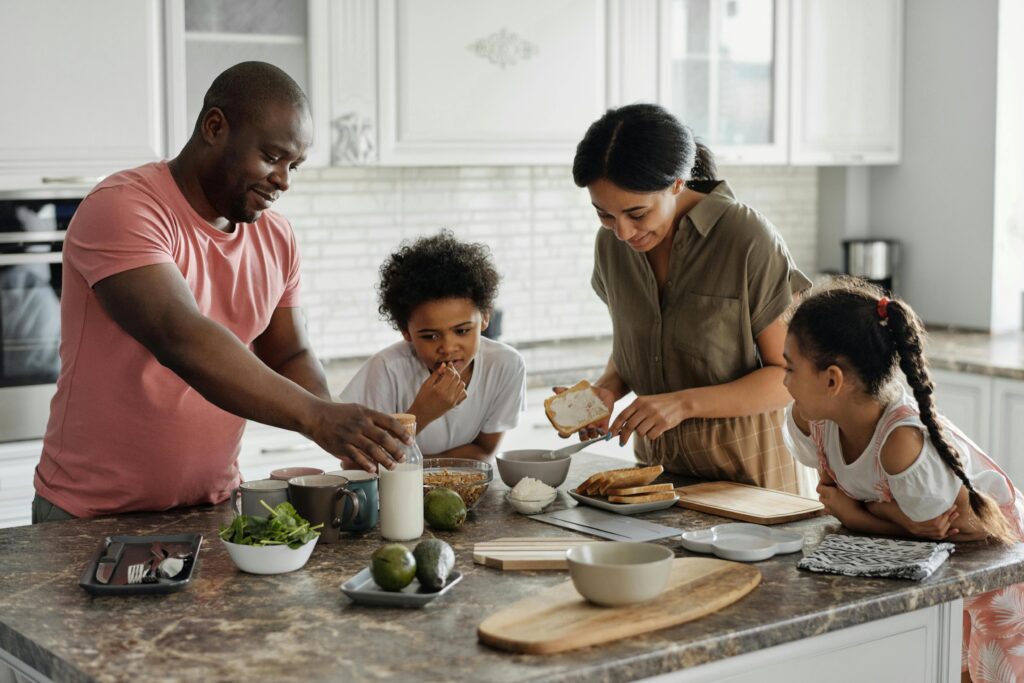 A family of four at the kitchen island having breakfast together.